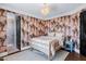 Relaxing bedroom features patterned wallpaper, hardwood floors, and a modern chandelier at 2339 E Virgo Pl, Chandler, AZ 85249