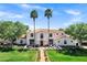 Stunning two-story home boasts a terracotta roof, palm trees, and a meticulously manicured lawn at 2339 E Virgo Pl, Chandler, AZ 85249
