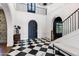 A large foyer boasts checkerboard tile floors, white walls and a staircase leading up to a second level at 2339 E Virgo Pl, Chandler, AZ 85249