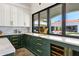 Kitchen features custom green cabinets, marble countertops, and a wine refrigerator, with a view to the backyard at 2339 E Virgo Pl, Chandler, AZ 85249
