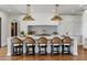 Kitchen island featuring marble countertops, custom barstools, and stylish pendant lights over herringbone floors at 2339 E Virgo Pl, Chandler, AZ 85249