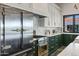 This kitchen includes a stainless steel refrigerator, stove, marble countertops, and custom green cabinets at 2339 E Virgo Pl, Chandler, AZ 85249