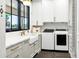 Bright laundry room with white cabinets, stone countertops, and modern washer/dryer at 2339 E Virgo Pl, Chandler, AZ 85249