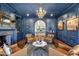 Charming blue living room with a fireplace, wet bar, hardwood floors and plush seating under an elegant chandelier at 2339 E Virgo Pl, Chandler, AZ 85249