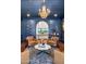 Bright blue living room with a fireplace, wet bar, hardwood floors, leather chairs and an elegant chandelier at 2339 E Virgo Pl, Chandler, AZ 85249