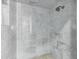 Walk-in shower with marble tiles, rainfall showerhead, and seamless glass enclosure at 2339 E Virgo Pl, Chandler, AZ 85249