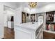 Luxurious walk-in closet with a large island, custom shelving and drawers, and hardwood floors at 2339 E Virgo Pl, Chandler, AZ 85249