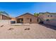 This backyard features gravel landscaping, a privacy fence, and a covered patio at 23676 W Parkway Dr, Buckeye, AZ 85326