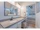 Bright bathroom featuring a modern vanity with solid surface counters, framed mirror and an adjoining bedroom at 23676 W Parkway Dr, Buckeye, AZ 85326