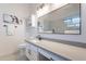 Bright bathroom featuring a modern vanity with solid surface counters and a framed mirror at 23676 W Parkway Dr, Buckeye, AZ 85326