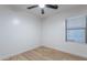 This bedroom features neutral paint, wood-look floors, and a window with blinds at 23676 W Parkway Dr, Buckeye, AZ 85326