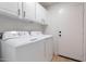 This laundry room features white cabinets, white doors, and a white washer and dryer at 23676 W Parkway Dr, Buckeye, AZ 85326