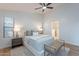 Bright main bedroom featuring neutral colors, wood floors, ensuite bathroom, ceiling fan, and generous natural light at 23676 W Parkway Dr, Buckeye, AZ 85326