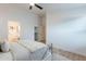 Bright main bedroom featuring neutral colors, wood floors, ceiling fan, a walk-in closet, and an ensuite bathroom at 23676 W Parkway Dr, Buckeye, AZ 85326