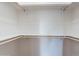 Empty walk-in closet with wooden rods, and built in shelves at 23676 W Parkway Dr, Buckeye, AZ 85326