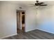 This bedroom showcases wood-look flooring, neutral walls, and a view into the adjacent bathroom at 244 E Ponderosa Ln, Phoenix, AZ 85022