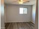This bright bedroom features wood-look floors, a ceiling fan, and natural light from a window at 244 E Ponderosa Ln, Phoenix, AZ 85022