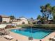 A serene pool surrounded by chairs and lush trees, is perfect for relaxation and recreation at 244 E Ponderosa Ln, Phoenix, AZ 85022