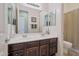 Bright bathroom with dual sinks, dark wood cabinets, and a large mirror at 2472 E Prescott Pl, Chandler, AZ 85249