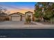 Inviting desert home with a three-car garage and well-maintained front yard under a colorful sunset sky at 2472 E Prescott Pl, Chandler, AZ 85249