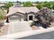 Charming single-story home featuring a three-car garage, desert landscaping, and a beautiful flowering tree at 2472 E Prescott Pl, Chandler, AZ 85249