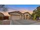 Exterior shot showcasing the home's spacious three-car garage and desert landscaping at 2472 E Prescott Pl, Chandler, AZ 85249