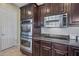 Modern kitchen with stainless steel oven, microwave, and dark wood cabinets offering contemporary convenience at 2472 E Prescott Pl, Chandler, AZ 85249