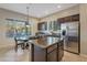 Bright kitchen with stainless steel appliances, dark cabinetry, island, and a breakfast nook with large windows at 2472 E Prescott Pl, Chandler, AZ 85249