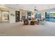 Cozy living room with a stone fireplace, built-in shelving, and large windows overlooking the backyard pool at 2472 E Prescott Pl, Chandler, AZ 85249