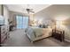Bright main bedroom with a tufted headboard, large windows, and a ceiling fan at 2472 E Prescott Pl, Chandler, AZ 85249