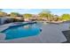 Sparkling pool with waterfall feature, surrounding patio, and well-maintained landscaping at 2472 E Prescott Pl, Chandler, AZ 85249
