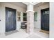 A welcoming entryway with black doors, stylish brickwork, and charming seating, creating a warm first impression at 2513 E Pleasant Ln, Phoenix, AZ 85042