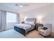 Bright main bedroom with neutral decor, side tables, lamps, and a comfortable sitting chair at 2513 E Pleasant Ln, Phoenix, AZ 85042