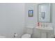 Clean powder room with a pedestal sink, toilet, and simple, modern decor at 2513 E Pleasant Ln, Phoenix, AZ 85042