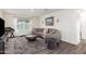 A cozy living room with a gray sectional, round coffee table, and a large window at 29491 N 122Nd Gln, Peoria, AZ 85383