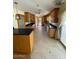 Spacious kitchen featuring wood cabinetry, dark countertops, and a tiled floor at 3144 N 84Th Pl, Scottsdale, AZ 85251