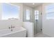 Bathroom showcasing a soaking tub, glass-enclosed shower, and natural light from multiple windows at 35234 N Barley St, San Tan Valley, AZ 85144