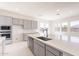 A large kitchen island with a stainless steel sink and modern faucet fixtures at 35234 N Barley St, San Tan Valley, AZ 85144