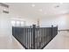 Open loft space with black railing, white walls and ceilings and tile floors at 35234 N Barley St, San Tan Valley, AZ 85144