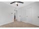 Bedroom with ceiling fan, neutral carpet, closet, and view to adjacent bathroom with hard surface flooring at 3607 N 79Th Ave, Phoenix, AZ 85033