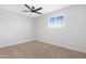 This bedroom features neutral carpet, a modern ceiling fan and a window with blinds at 3607 N 79Th Ave, Phoenix, AZ 85033