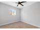 Bright bedroom featuring a ceiling fan, neutral carpet and paint, and a window providing natural light at 3607 N 79Th Ave, Phoenix, AZ 85033