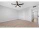 This bedroom features neutral carpet, a modern ceiling fan and a closet with white doors at 3607 N 79Th Ave, Phoenix, AZ 85033