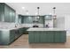Stunning kitchen with green cabinets, granite counters, stainless appliances and a large center island at 3607 N 79Th Ave, Phoenix, AZ 85033