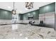 Modern kitchen with a spacious granite island and stainless-steel appliances and stylish lighting at 3607 N 79Th Ave, Phoenix, AZ 85033
