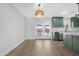 Open-concept living space with French doors and kitchen access with granite counters and green cabinetry at 3607 N 79Th Ave, Phoenix, AZ 85033