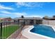 Backyard with a sparkling in-ground pool and patio area, enclosed by a black wrought iron fence at 3607 N 79Th Ave, Phoenix, AZ 85033