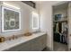 Elegant bathroom with double vanities, modern lighting, and a doorway to a walk-in closet at 3626 N Mohave Way, Scottsdale, AZ 85251