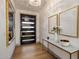 Elegant entryway featuring wood floors, modern light fixture, console table with art, and a stylish front door at 3626 N Mohave Way, Scottsdale, AZ 85251