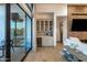 Living room bar with glass cabinets, brick accent wall, and wine storage at 3626 N Mohave Way, Scottsdale, AZ 85251